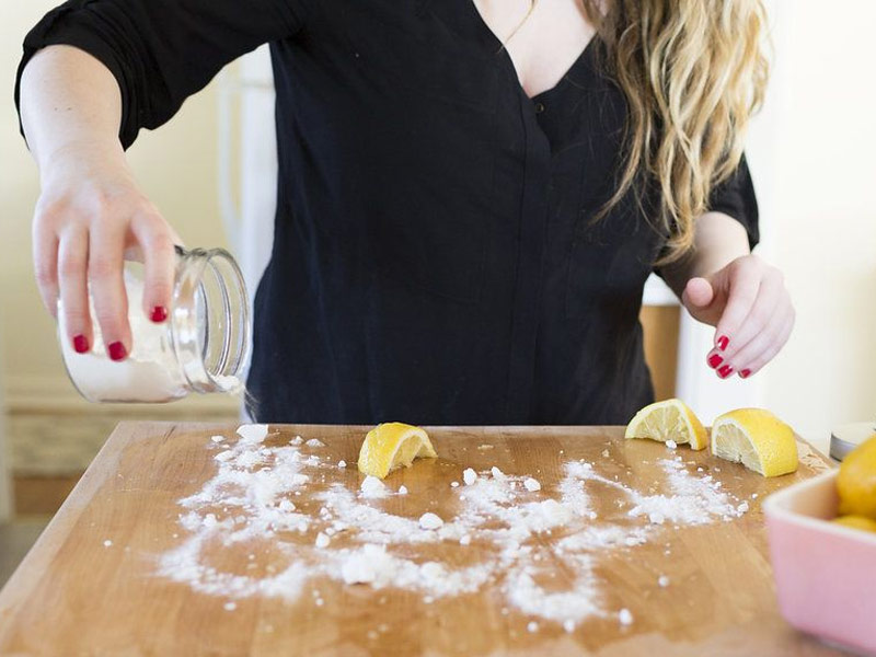 Clean wooden cutting board with lemon and salt